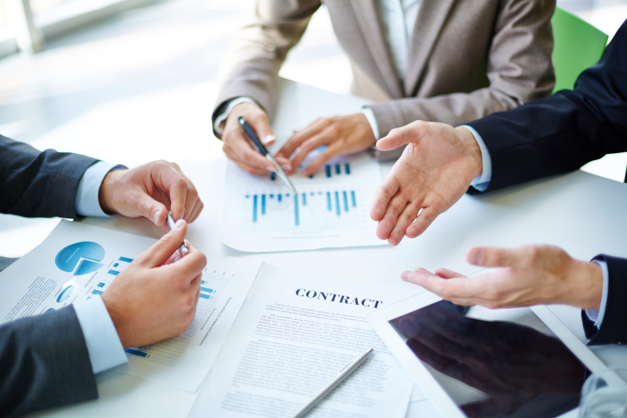 Image of business partners hands over business objects on workplace at meeting